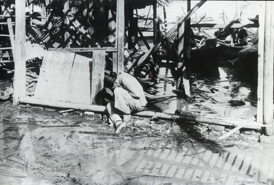 1938年7-9月間，漢口，一次日軍的空襲之后，在被毀的家園前哀傷的婦女。