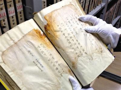　4月30日，吉林省檔案館庫房內(nèi)，趙玉潔展示一冊檔案，庫房內(nèi)恒溫恒濕，每天都會有例行的安全檢查。新京報記者 盧美慧 攝