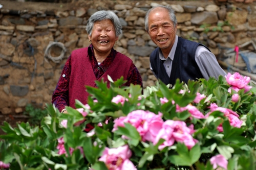 　5月13日，許潤枕（右）和老伴兒董振賢在牡丹花前合影。