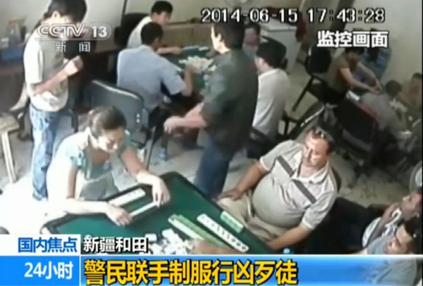 綠衣男子掏出斧頭砍向牌客，此時，白衣男子扔若無其事。