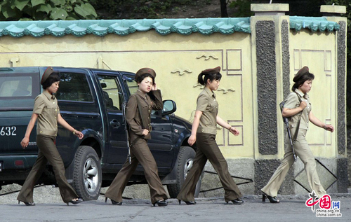 當(dāng)?shù)貢r(shí)間2014年6月23日，朝鮮新義州，朝鮮女兵身著軍裝從河邊走過(guò)。