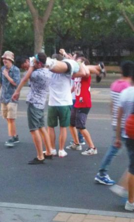 四名外籍男子一同扛起醉漢拍照。
