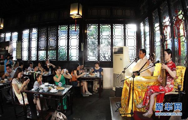 7月20日早晨，游客在參加蘇州拙政園“私人定制”的早游之后邊品嘗當?shù)孛朗尺呅蕾p蘇州評彈。為避開炎夏高溫，蘇州拙政園推出“私人定制”早游活動。