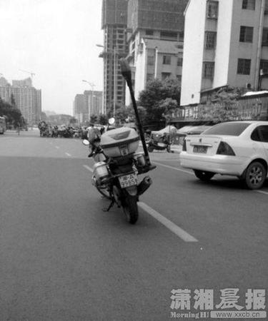 警務(wù)摩托車的車牌為“湘A9985警”，停放在主行駛道上。圖片來自微博