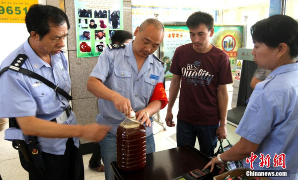 資料圖：7月29日，公安民警和安保人員正在克拉瑪依客運站進(jìn)站口嚴(yán)查進(jìn)站旅客行李和違禁物品。 周建玲 攝