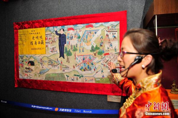 。圖為工作人員介紹1954年十世班禪額爾德尼敬獻(xiàn)給中央政府的唐卡。