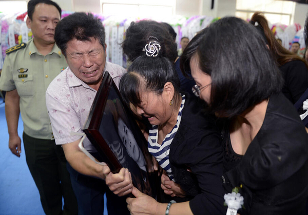 圖為追悼會完畢時，謝樵的父母親緊緊抱住遺像。