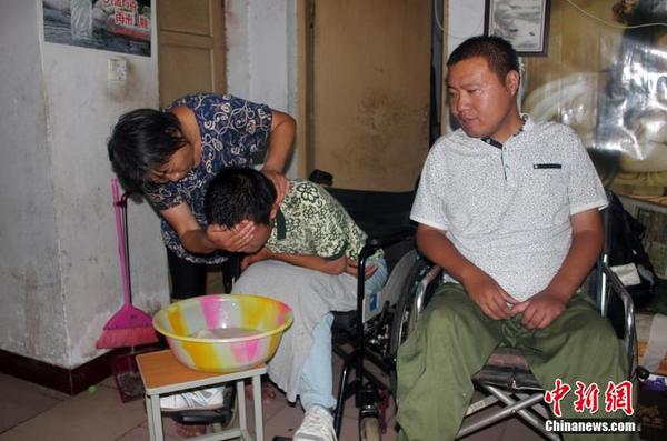 為了給52歲的母親減少負(fù)擔(dān)，兄弟二人經(jīng)常半個(gè)多月都不洗漱。見記者前來兄弟二人才特意請(qǐng)母親給自己洗把臉。 馬義恒 攝
