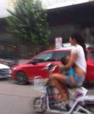媽媽邊騎車邊給孩子喂奶。