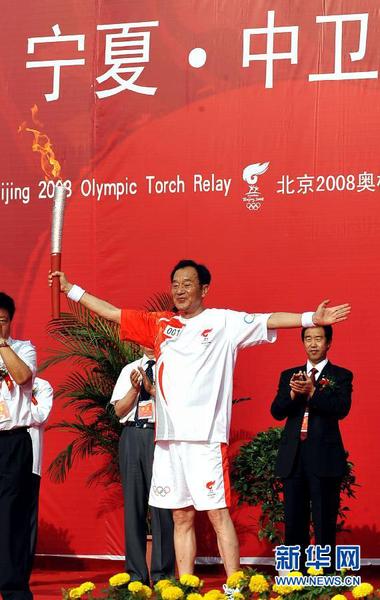 2008年6月29日，北京奧運(yùn)圣火在寧夏中衛(wèi)傳遞，火炬手張賢亮在起跑儀式上高舉火炬。