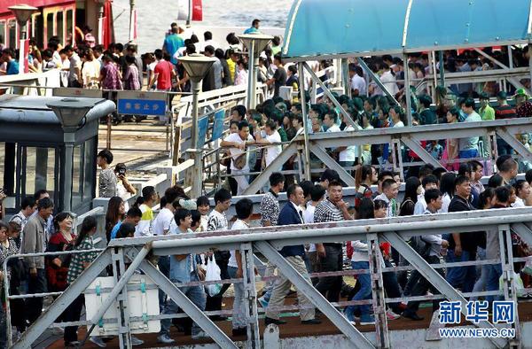 10月1日，游客在上海外灘排隊乘坐觀光游輪。當日是國慶長假第一天，全國各地旅游景點游人如織。 新華社記者 丁汀 攝