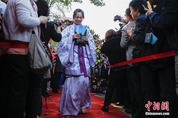 10月16日，身著漢服的學(xué)生走過“成人門”和紅地毯。