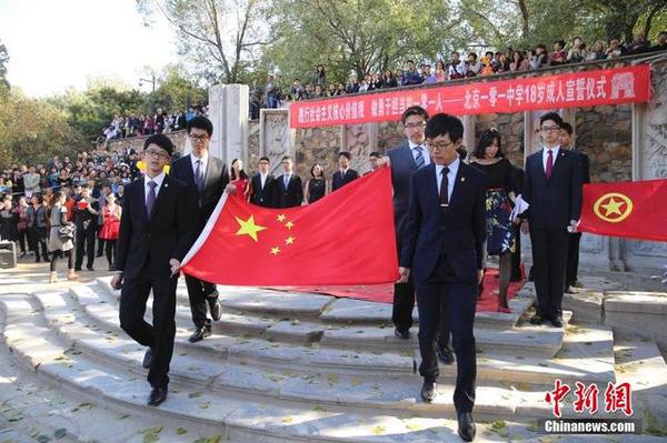 10月16日，學(xué)生們舉起老師們贈送的國旗。