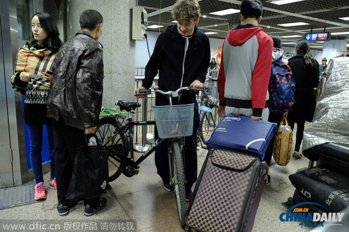 2014年10月29日，北京，三外國男子推“二六”自行車欲從大望路地鐵站過安檢進(jìn)入地鐵。根據(jù)地鐵相關(guān)規(guī)定，自行車等超大件物品禁止進(jìn)入地鐵，遂被工作人員攔阻。