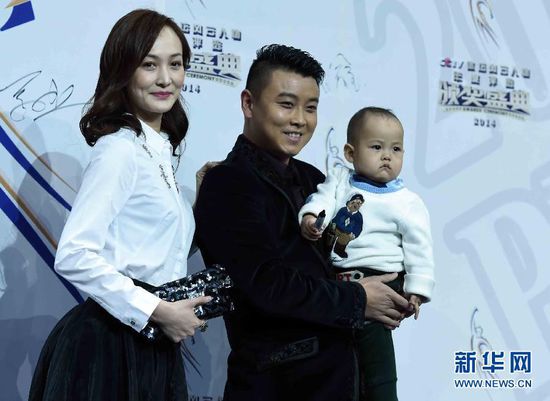 2月1日，前乒乓球國(guó)手王皓（中）抱著兒子小樂天與妻子閆博雅在頒獎(jiǎng)典禮紅毯儀式上合影。當(dāng)日，“2014CCTV體壇風(fēng)云人物年度評(píng)選”頒獎(jiǎng)典禮在京舉行。 新華社記者公磊攝