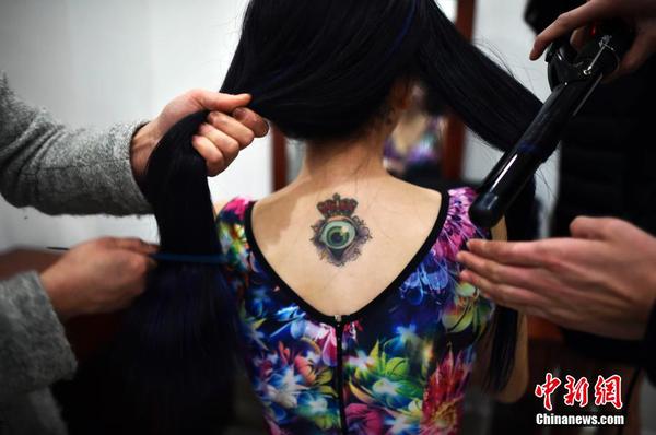 　一位舉牌女郎后背上的紋身。中新社發(fā) 稻草 攝 圖片來源：CNSPHOTO