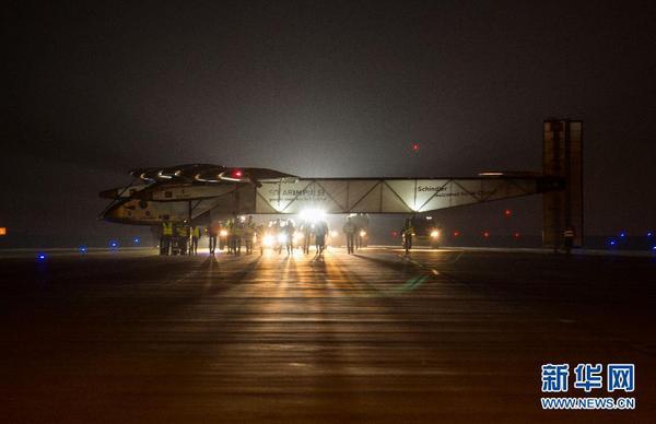 31日凌晨，工作人員在停機坪上推著太陽能飛機向臨時搭建的專用機庫前行。