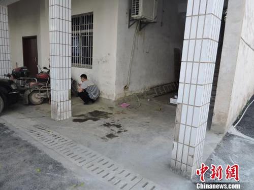圖為該男子蹲在墻角處專(zhuān)心上網(wǎng)。　劉洋　攝