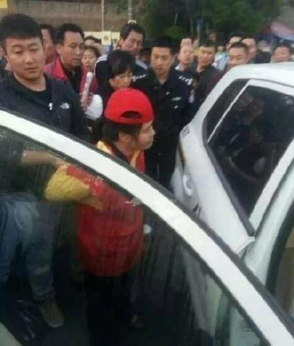 女志愿者被民警帶上警車，受傷女子則被送醫(yī)救治。