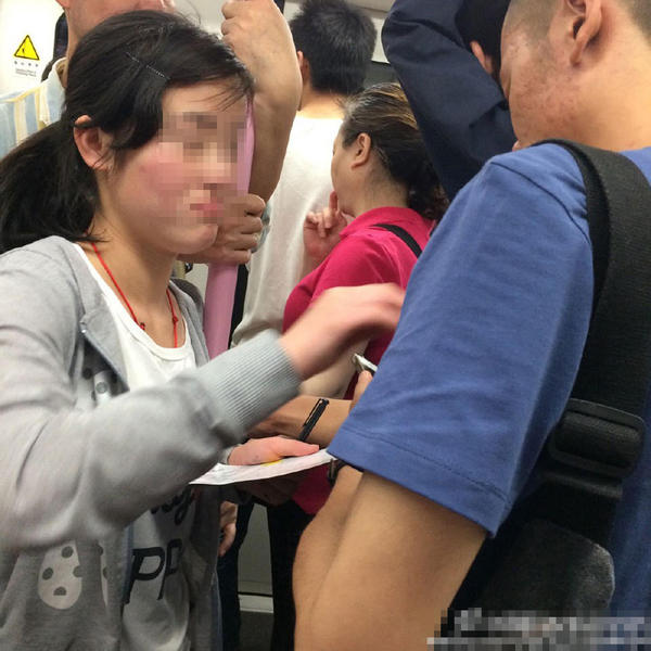 武漢地鐵上的乞討女孩對(duì)男乘客進(jìn)行摸胸討錢。