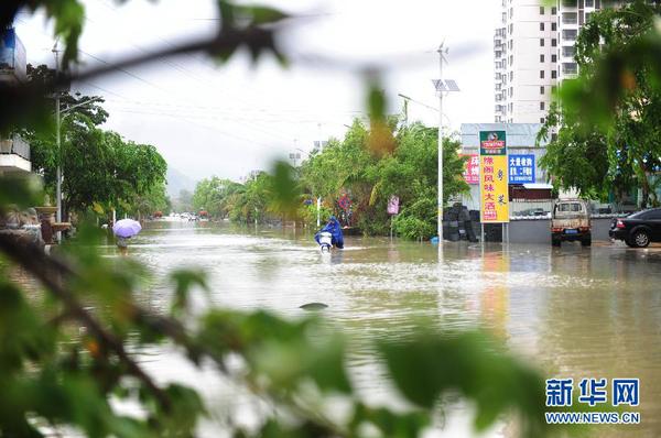 6月23日，在海南省三亞市，人們?cè)诜e水路段涉水前行。今年第8號(hào)臺(tái)風(fēng)“鯨魚”已于6月22日18時(shí)50分左右在海南省萬寧市沿海登陸，臺(tái)風(fēng)給三亞帶來了強(qiáng)風(fēng)降雨天氣，影響市民正常出行。新華社發(fā)（沙曉峰 攝）