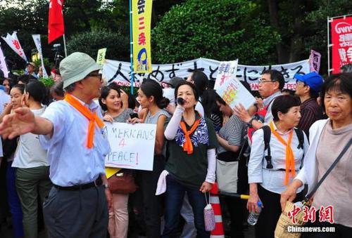 7月15日，安倍政權強推以解禁集體自衛(wèi)權為核心的安保法案在眾議院特別委員會表決過關，引發(fā)日本民意強烈反彈。當天上午起在國會周邊出現(xiàn)的自發(fā)抗議活動，到晚間達到高峰：數(shù)萬市民圍聚到國會周邊抗議示威，表達內(nèi)心憤怒和擔憂。王健 攝