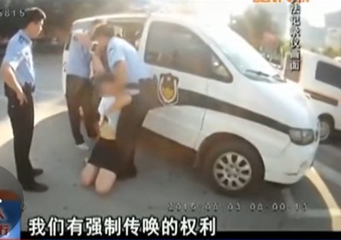 就在警察想把她從地上拉起來(lái)時(shí)，該女子突然伸手解開(kāi)自己上衣衣扣