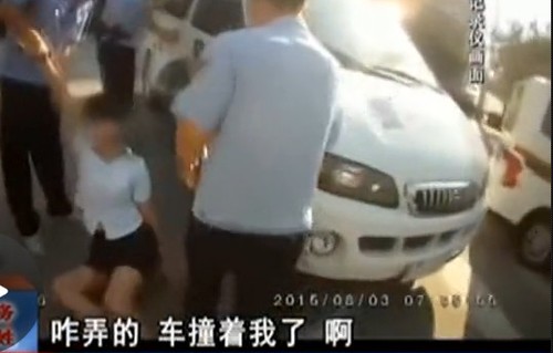 在拉扯中，女子撞到警車上。