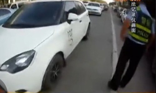 　由于路口被堵，民警只好指揮車輛從旁邊繞行。