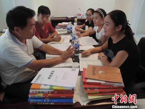 圖為在中牟縣城一個(gè)小區(qū)的學(xué)習(xí)點(diǎn)，幾名正在準(zhǔn)備公考的考生正在和郭宗強(qiáng)進(jìn)行交流。