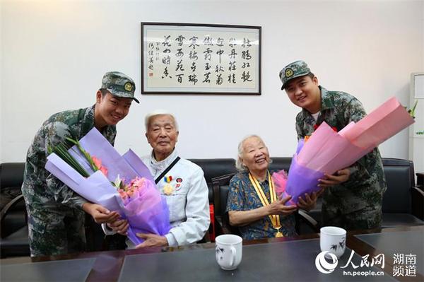 岳麓區(qū)即將去往駐港部隊(duì)的新兵代表為抗戰(zhàn)老兵方耀寰、惲順芳送上鮮花與月餅，祝福老人節(jié)日快樂。 胡丹 攝