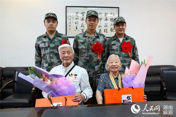 9月8日，岳麓區(qū)即將去往駐港部隊(duì)的新兵代表為抗戰(zhàn)老兵方耀寰、惲順芳送上鮮花與月餅，祝福老人節(jié)日快樂。 胡丹 攝