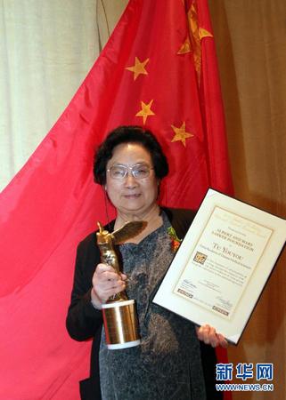這是2011年9月23日，屠呦呦在美國紐約舉行的拉斯克獎頒獎儀式上展示獎杯和證書。