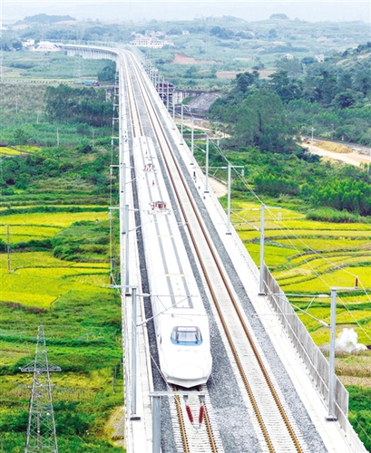 　12月3日，一輛試運(yùn)行的“和諧號(hào)”列車從廣西南寧市隆安縣境內(nèi)的一座高架橋經(jīng)過。韋萬忠攝（新華社發(fā)）