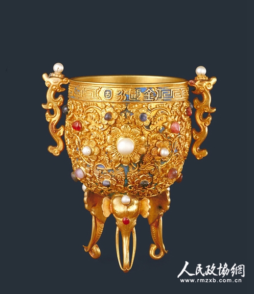 金甌永固杯 杯金質(zhì)，鼎式，圓形，直口?？谘冂Y回紋一周，一面中部鏨篆書“金甌永固”，一面鏨“乾隆年制”四字款。