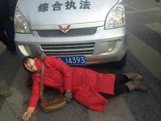 試圖阻擋的紅衣女子躺在地上。視頻截圖