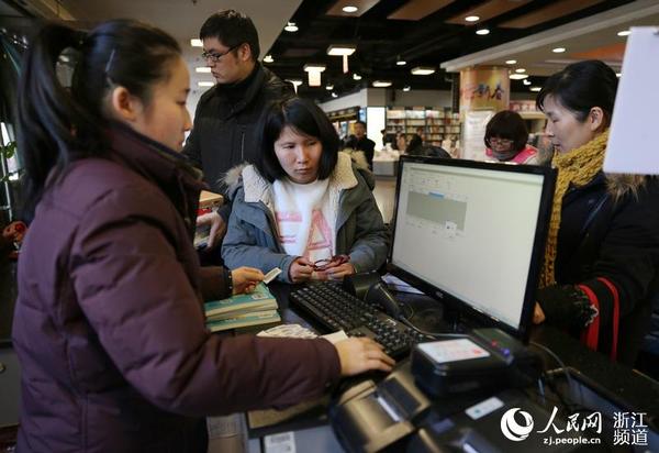 書店服務(wù)員幫助市民查閱該書是否可外借。
