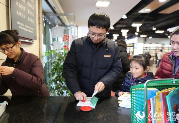 圖書管理員給新書加蓋杭州圖書館公章。
