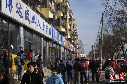 2016年2月19日，在北京市通州區(qū)馬駒橋商業(yè)街上，一些外來務(wù)工人員到此尋找工作。呂春榮 攝