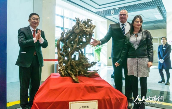 中國(guó)僑聯(lián)副主席喬衛(wèi)（左）與捐贈(zèng)人夫婦為九龍木雕揭幕