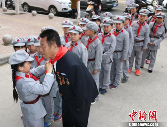 受谷殿明血雷鋒事跡的感染，雷鋒小標(biāo)兵為這位“活雷鋒”爺爺系上紅領(lǐng)巾。　郭園 攝