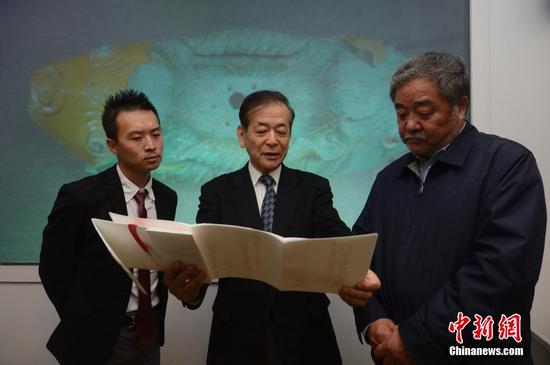　　3月28日，牟田口章人（圖中）向內(nèi)蒙古博物院院長（圖右）介紹捐贈的文獻(xiàn)。當(dāng)日，日本帝塚山大學(xué)文化創(chuàng)造學(xué)科教授牟田口章人在呼和浩特，向內(nèi)蒙古博物院捐贈了遼代文物“雙魚形琉璃釉建筑構(gòu)件”。據(jù)悉，該文物是他在日本自己出資購得，同時他還代友人捐助了遼代歷史研究文獻(xiàn)。中新社記者 劉文華 攝