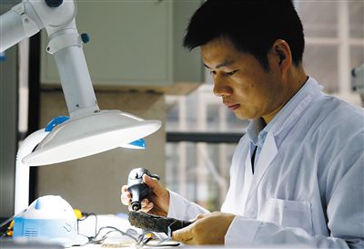 省博文保人員在對一件鐵器進(jìn)行除銹處理。省博文保人員采集浸泡華光礁I號船板的離子水進(jìn)行化學(xué)分析。
