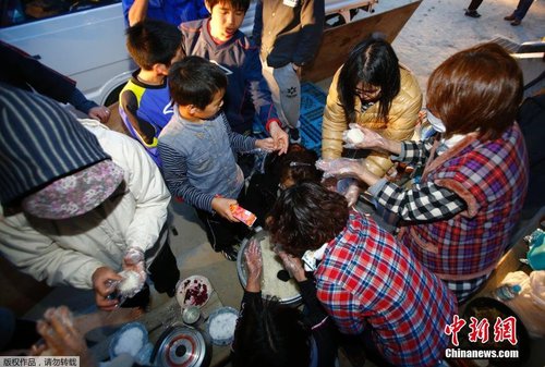 當(dāng)?shù)貢r間4月17日，志愿者在公園的空地上制作飯團(tuán)發(fā)放給小朋友。