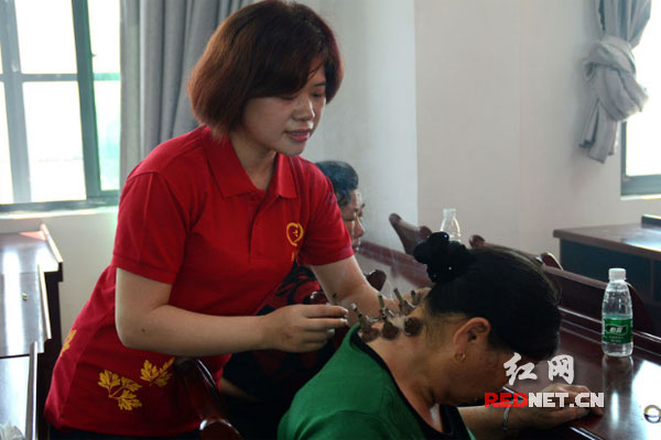 愛(ài)心團(tuán)隊(duì)的護(hù)師和志愿者為老年人進(jìn)行艾灸理療。