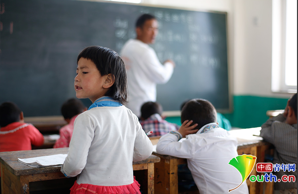 　6歲的藏族女孩黃娜姆措站著聽黃老師講課。黃三英的課堂上氛圍很活躍，孩子們跟黃老師一起，又學習、又玩耍。中國青年網(wǎng)記者 張炎良 攝