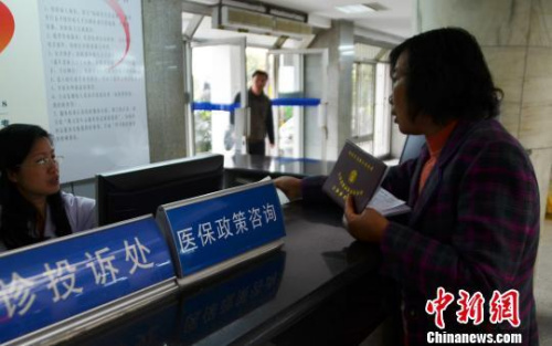 資料圖。一名女子在醫(yī)保政策咨詢臺前咨詢?！⊥跛颊?攝