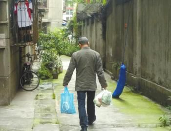 成都某中學(xué)外的小區(qū)內(nèi)，一家長用中午空閑時(shí)間給住在這里的孩子買菜做飯。