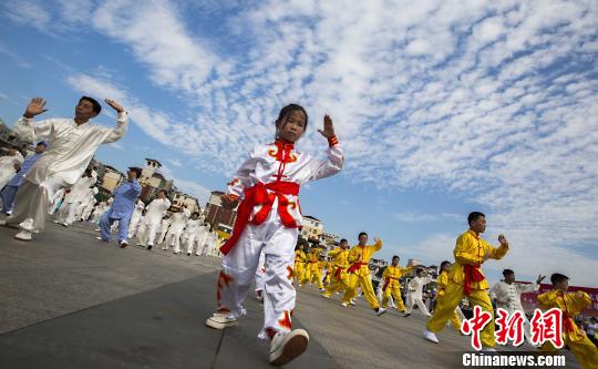 少年太極拳愛好者在江西都昌縣一廣場上表演太極拳?！「到ū蟆z
