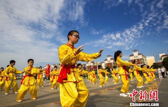 身著黃色統(tǒng)一古式服裝的少年打太極拳。　傅建斌　攝
